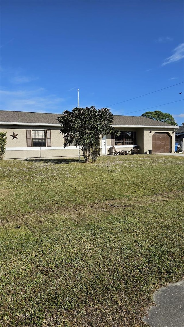 ranch-style house featuring a front yard and a garage