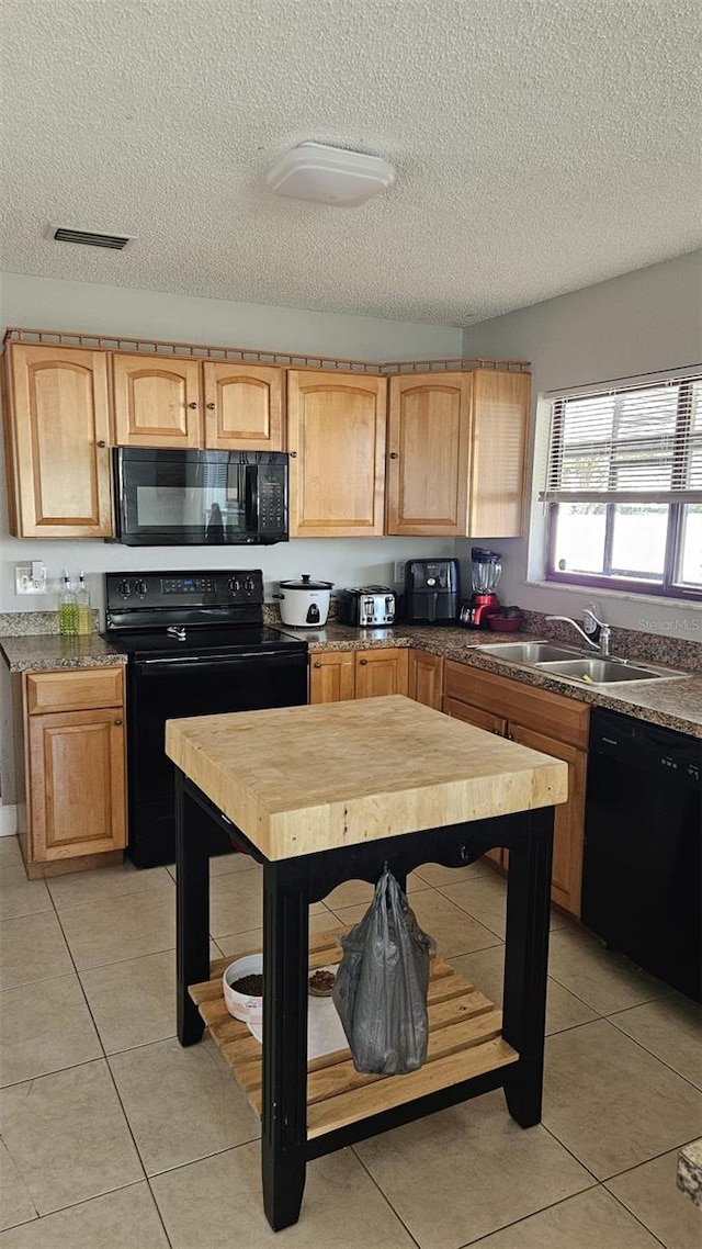 kitchen with black appliances, light tile patterned flooring, sink, and a textured ceiling