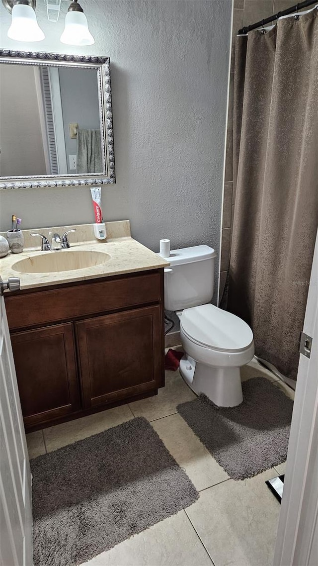 bathroom featuring tile patterned flooring, vanity, toilet, and a shower with shower curtain