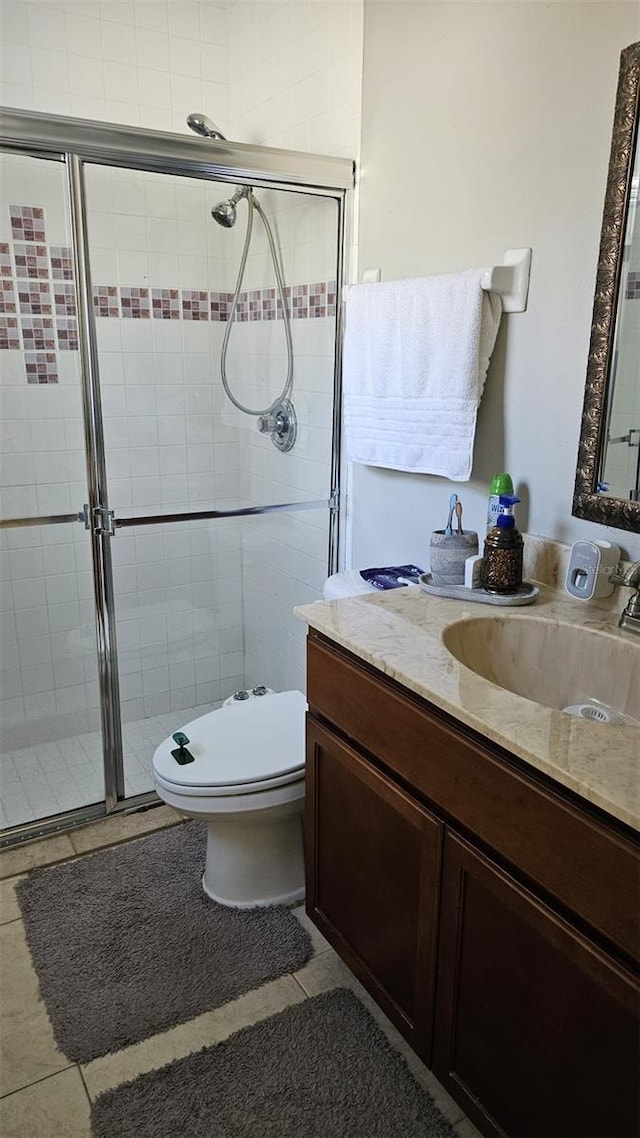 bathroom with toilet, tile patterned flooring, vanity, and walk in shower