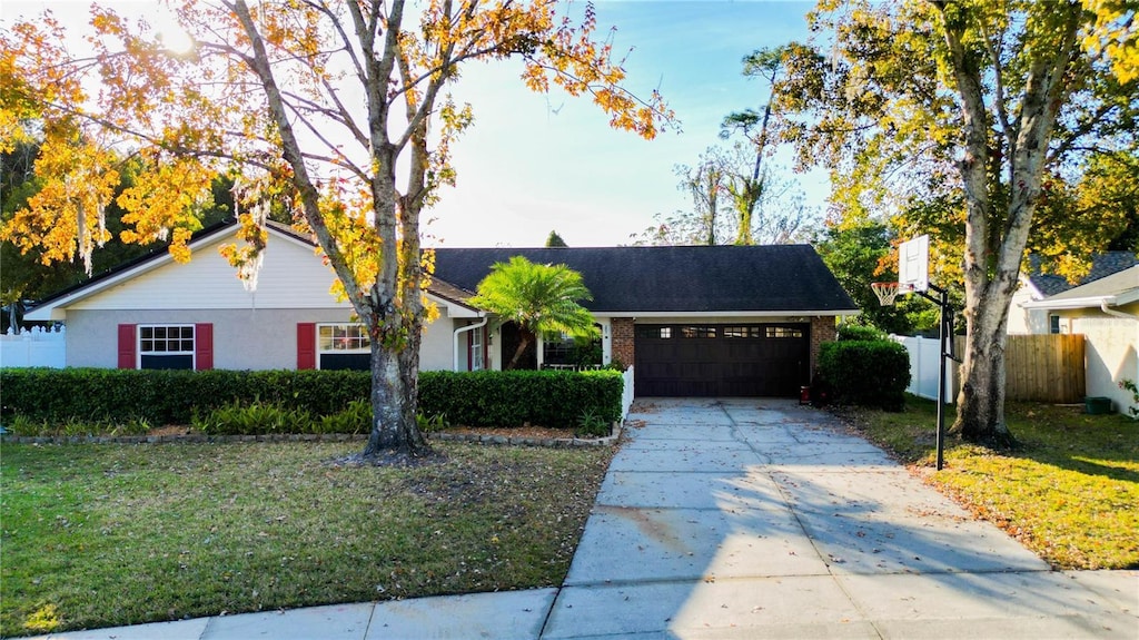 single story home with a garage and a front lawn