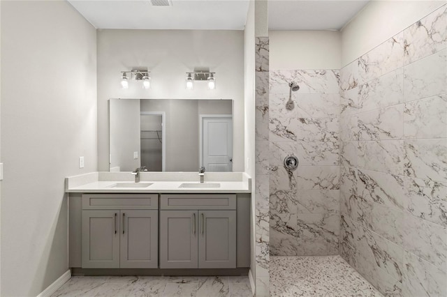 bathroom featuring tiled shower and vanity