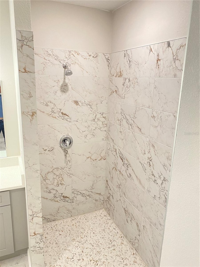 bathroom with vanity and a tile shower