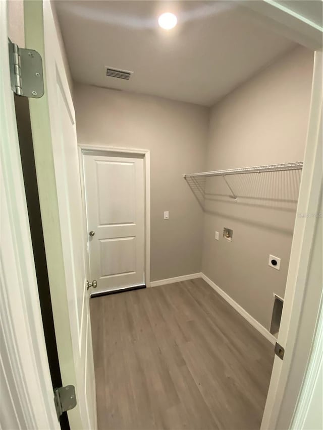 laundry area featuring electric dryer hookup and hardwood / wood-style flooring