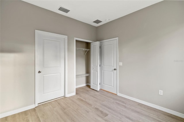 unfurnished bedroom with a closet and light hardwood / wood-style floors