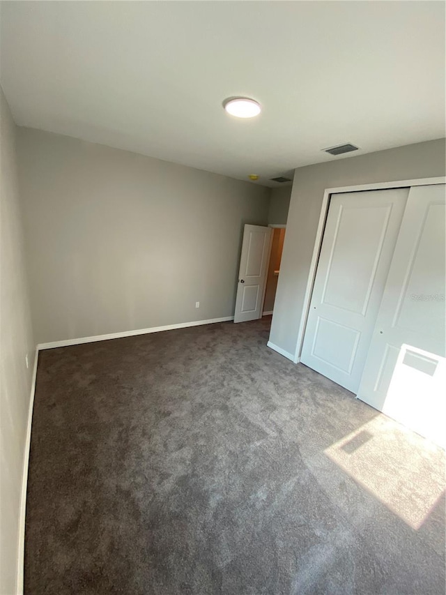 unfurnished bedroom featuring carpet flooring and a closet