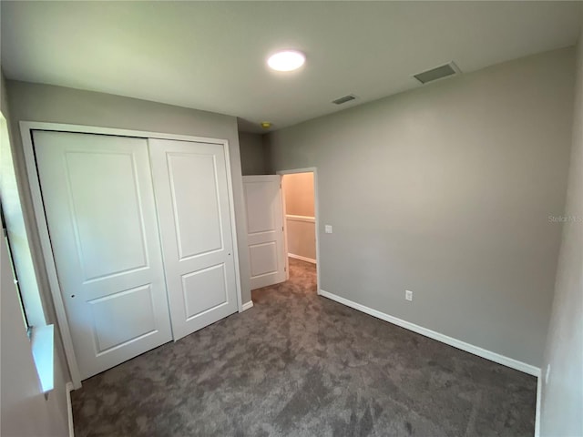 unfurnished bedroom with a closet and dark carpet