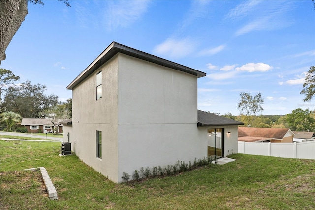 view of home's exterior with a lawn and central AC