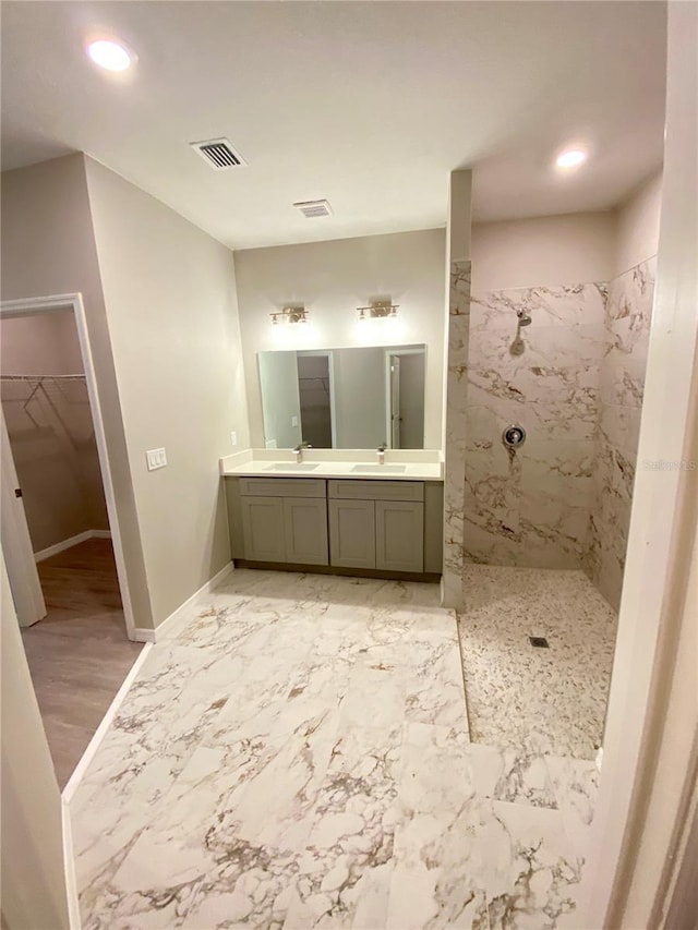 bathroom featuring tiled shower, vanity, and hardwood / wood-style flooring