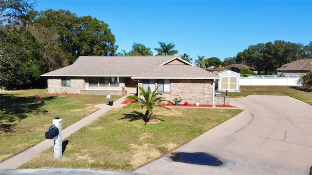 single story home with a front yard and a shed