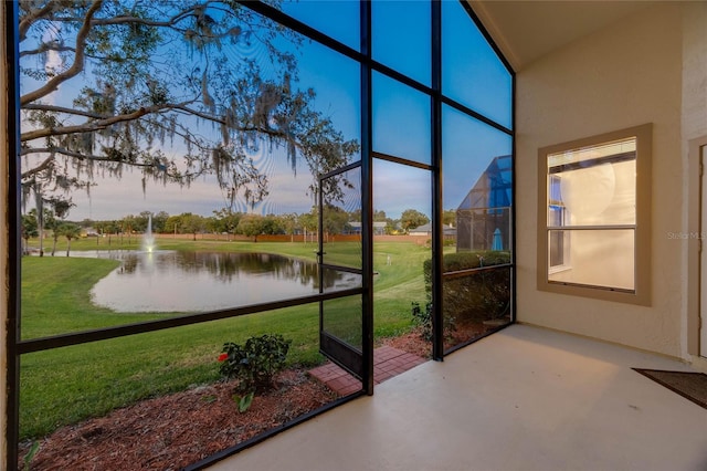 unfurnished sunroom featuring a water view