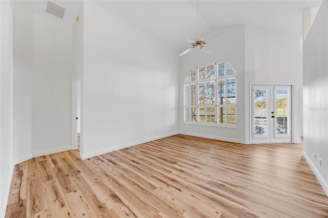 interior space with light hardwood / wood-style flooring, high vaulted ceiling, and french doors