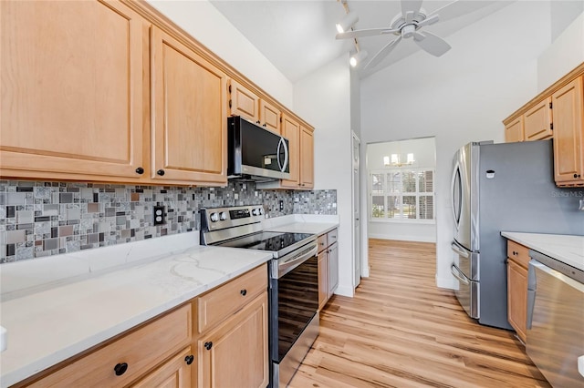 kitchen featuring ceiling fan with notable chandelier, light brown cabinetry, tasteful backsplash, light hardwood / wood-style floors, and stainless steel appliances