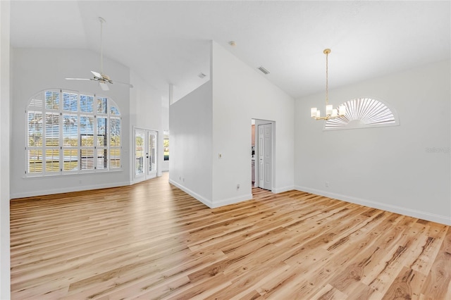 interior space featuring ceiling fan with notable chandelier, light hardwood / wood-style floors, and high vaulted ceiling