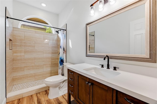 bathroom featuring a shower with shower curtain, vanity, hardwood / wood-style flooring, and toilet