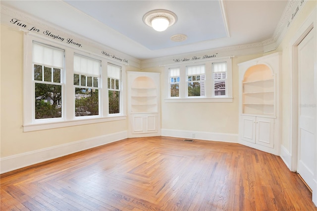 empty room with built in features and hardwood / wood-style floors