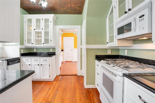 kitchen with white cabinets, white appliances, and light hardwood / wood-style flooring