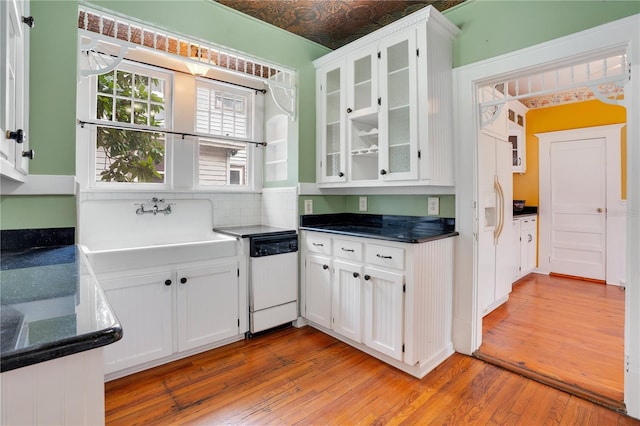 kitchen featuring white cabinets, white dishwasher, and light wood-type flooring