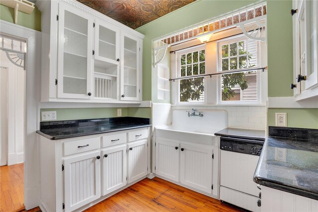 kitchen with sink, dishwasher, tasteful backsplash, light hardwood / wood-style flooring, and white cabinets