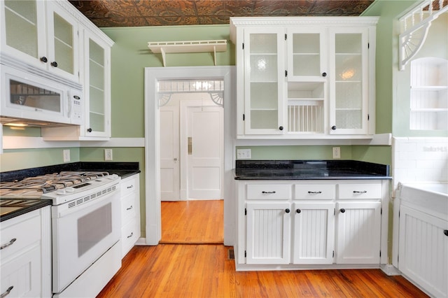 kitchen featuring light hardwood / wood-style flooring, white cabinets, and white appliances