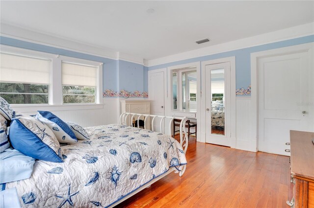 bedroom with hardwood / wood-style floors and ornamental molding