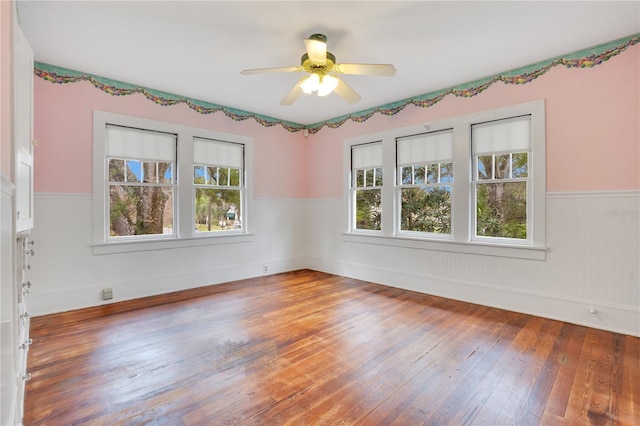 spare room with hardwood / wood-style floors, a wealth of natural light, and ceiling fan