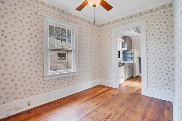 spare room with hardwood / wood-style floors, sink, and crown molding