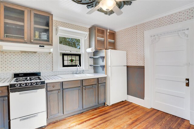 kitchen with white appliances, sink, ceiling fan, light wood-type flooring, and ornamental molding