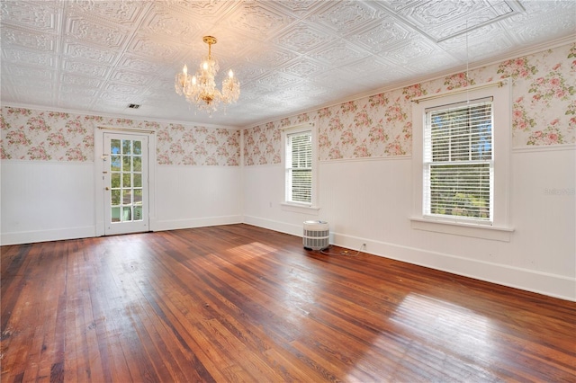 empty room with a chandelier and dark hardwood / wood-style floors