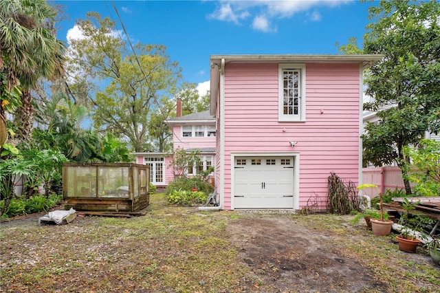 rear view of house with a garage