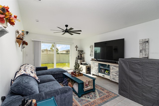 living room featuring tile patterned flooring, a textured ceiling, and ceiling fan