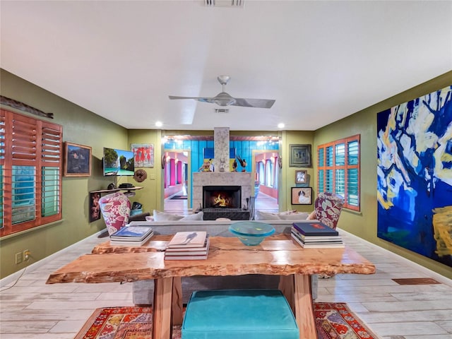 interior space featuring ceiling fan, a fireplace, and light hardwood / wood-style floors