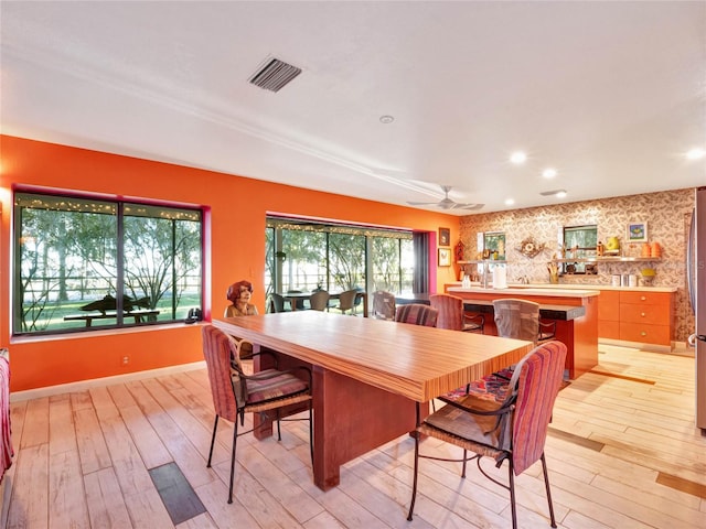 dining area with ceiling fan and light hardwood / wood-style flooring