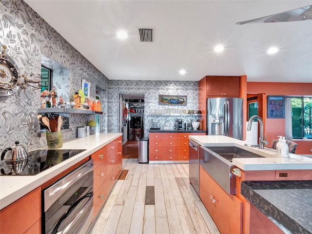 kitchen with light hardwood / wood-style flooring and appliances with stainless steel finishes