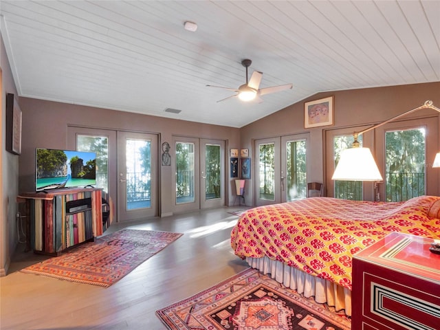 bedroom with hardwood / wood-style floors, lofted ceiling, access to outside, and french doors