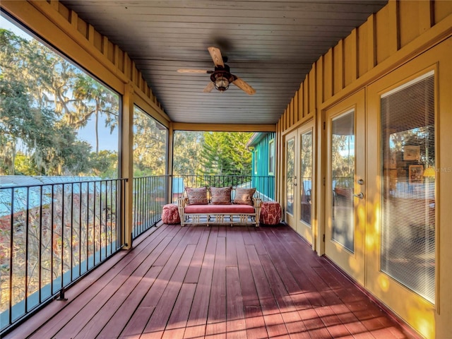 unfurnished sunroom featuring ceiling fan