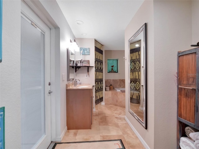 bathroom featuring vanity, a relaxing tiled tub, and tile patterned floors