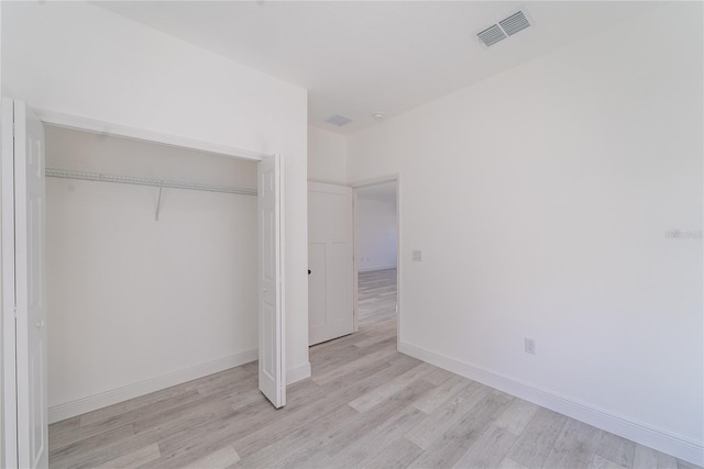 unfurnished bedroom featuring light wood-type flooring and a closet