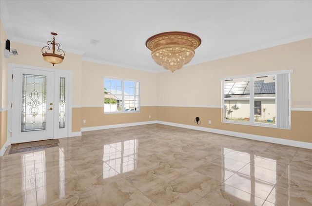 foyer entrance featuring ornamental molding and an inviting chandelier