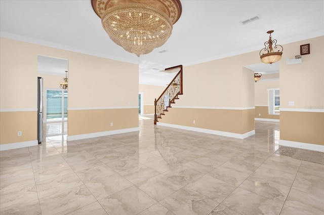 spare room featuring a notable chandelier and ornamental molding