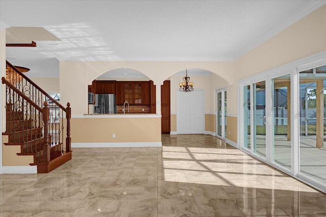 interior space featuring ornamental molding, sink, and a chandelier