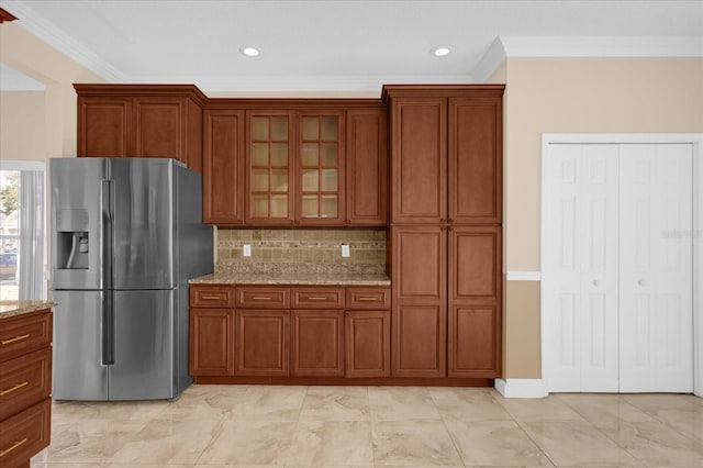 kitchen featuring decorative backsplash, stainless steel fridge with ice dispenser, crown molding, and light stone countertops