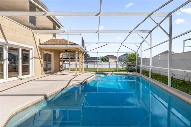 view of swimming pool featuring ceiling fan, a lanai, and a patio