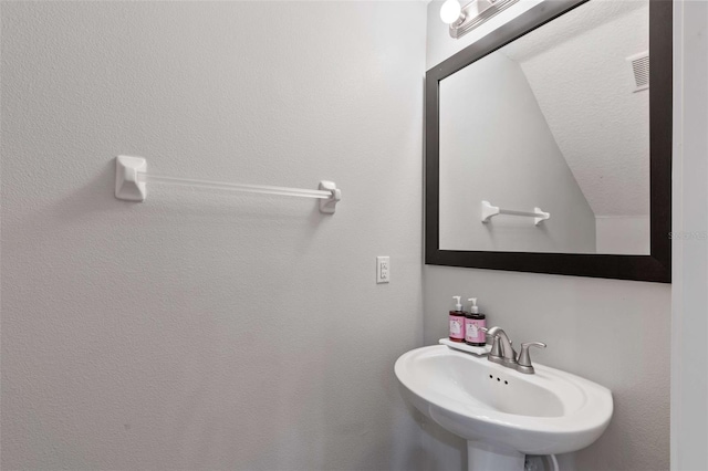 bathroom with lofted ceiling and sink