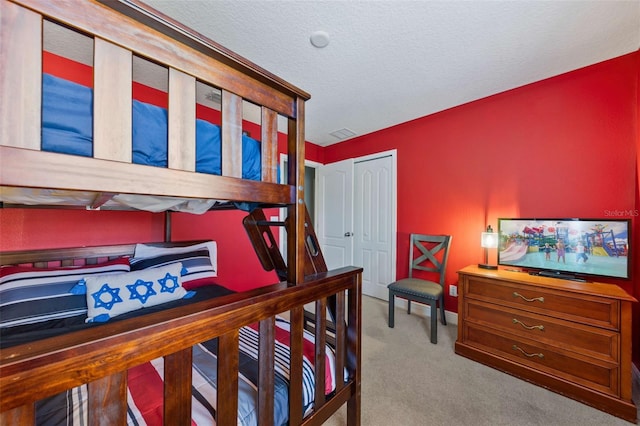 bedroom featuring carpet and a textured ceiling