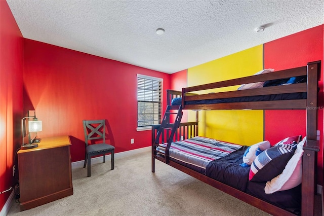 bedroom with light colored carpet and a textured ceiling