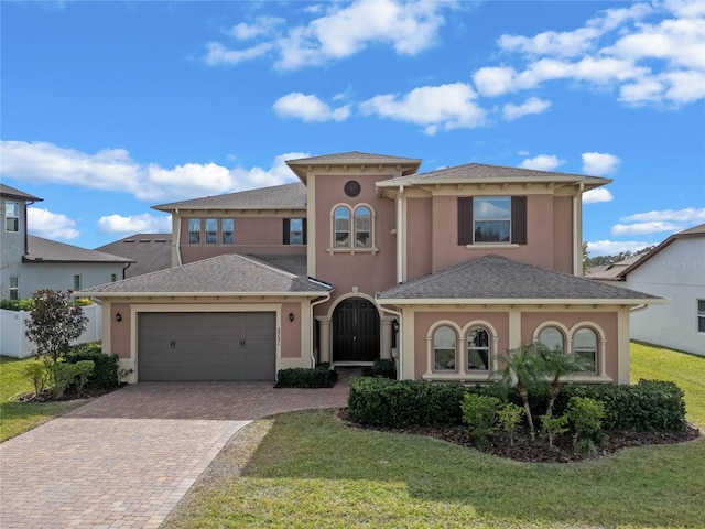 mediterranean / spanish home featuring a garage and a front yard