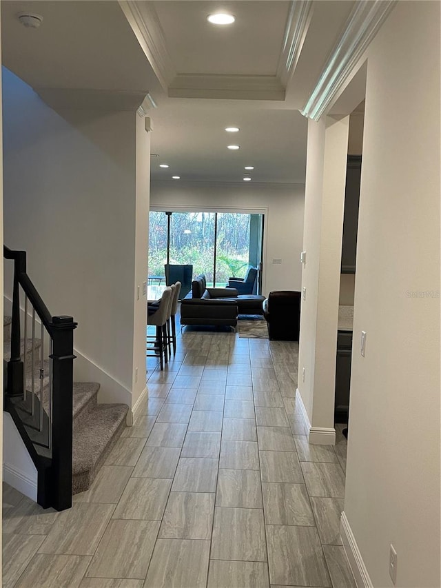 hall featuring a tray ceiling and crown molding