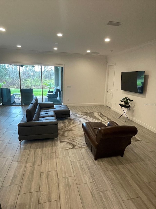 living room with light wood-type flooring and ornamental molding