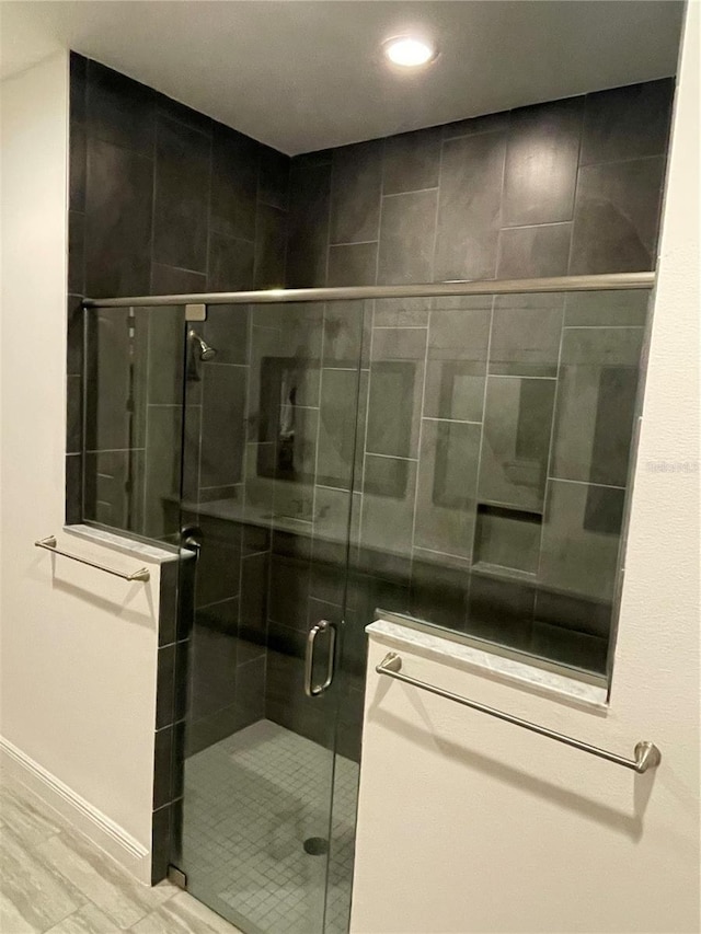 bathroom featuring a shower with door